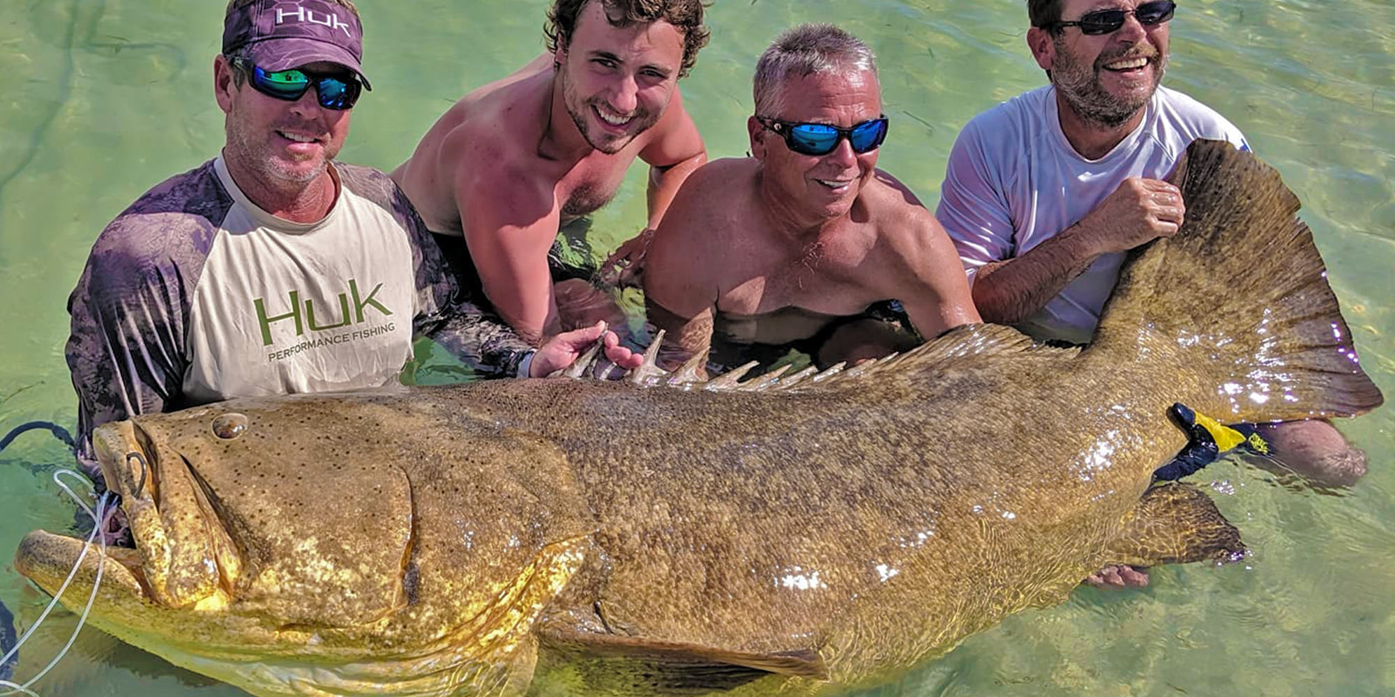 Florida Inshore Xtream Boca Grande Fishing Guide customers posing with an enormous Gliath Grouper. they caught off the coast of Boca Grande, Florida.