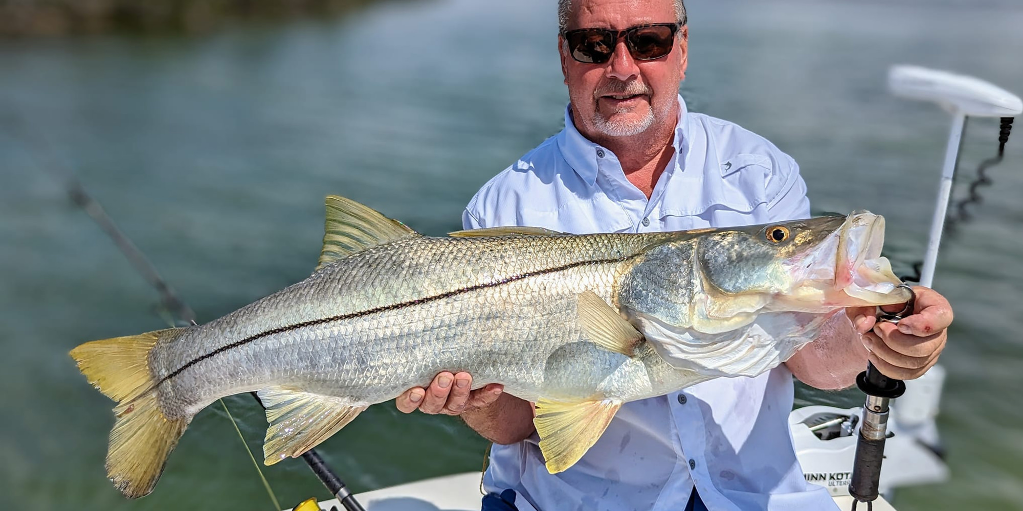 Florida Inshore Xtream Fishing Guide customer holding up a snook caught off Boca Grande on a Nearshore Fishing Charter in the waters of southern Florida.