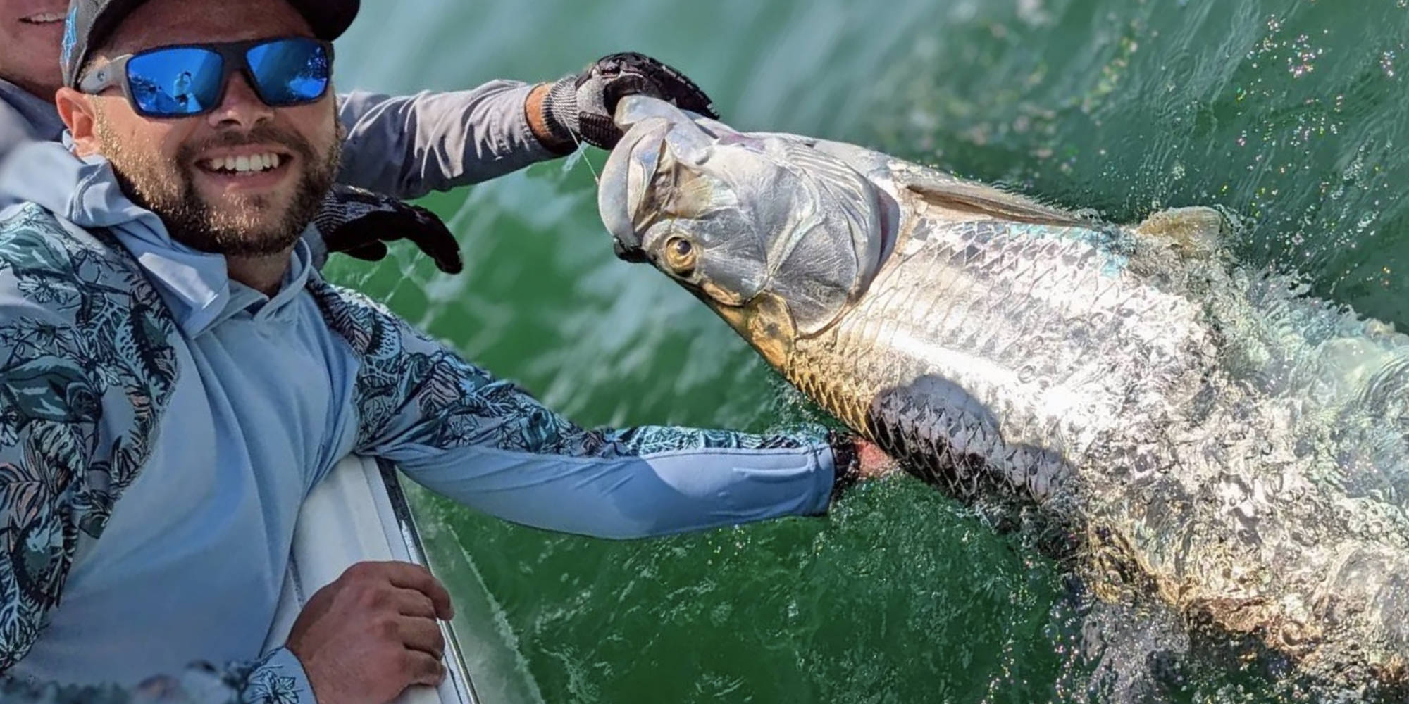 Florida Inshore Xtream Fishing Charter customer holding up a huge tarpon caught off Boca Grande in the Gulf of Mexico.